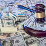 Auction concept - judges gavel against us dollar background.