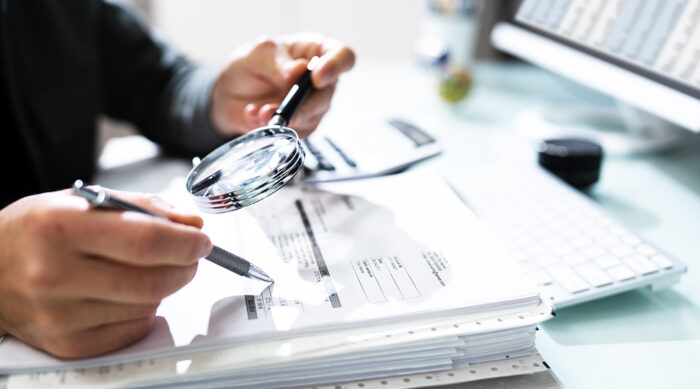 A male tax lawyer analyzes a tax audit document for a business.