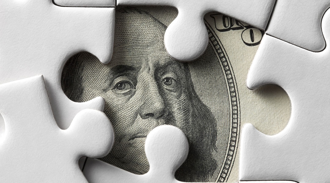 Close up view of Benjamin Franklin’s face on green monetary bills.