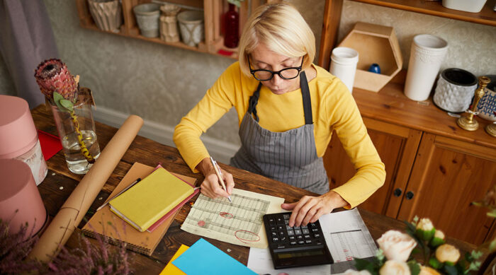 A blonde businesswoman wearing glasses and a yellow shirt analyzes business state and local tax in Ohio.