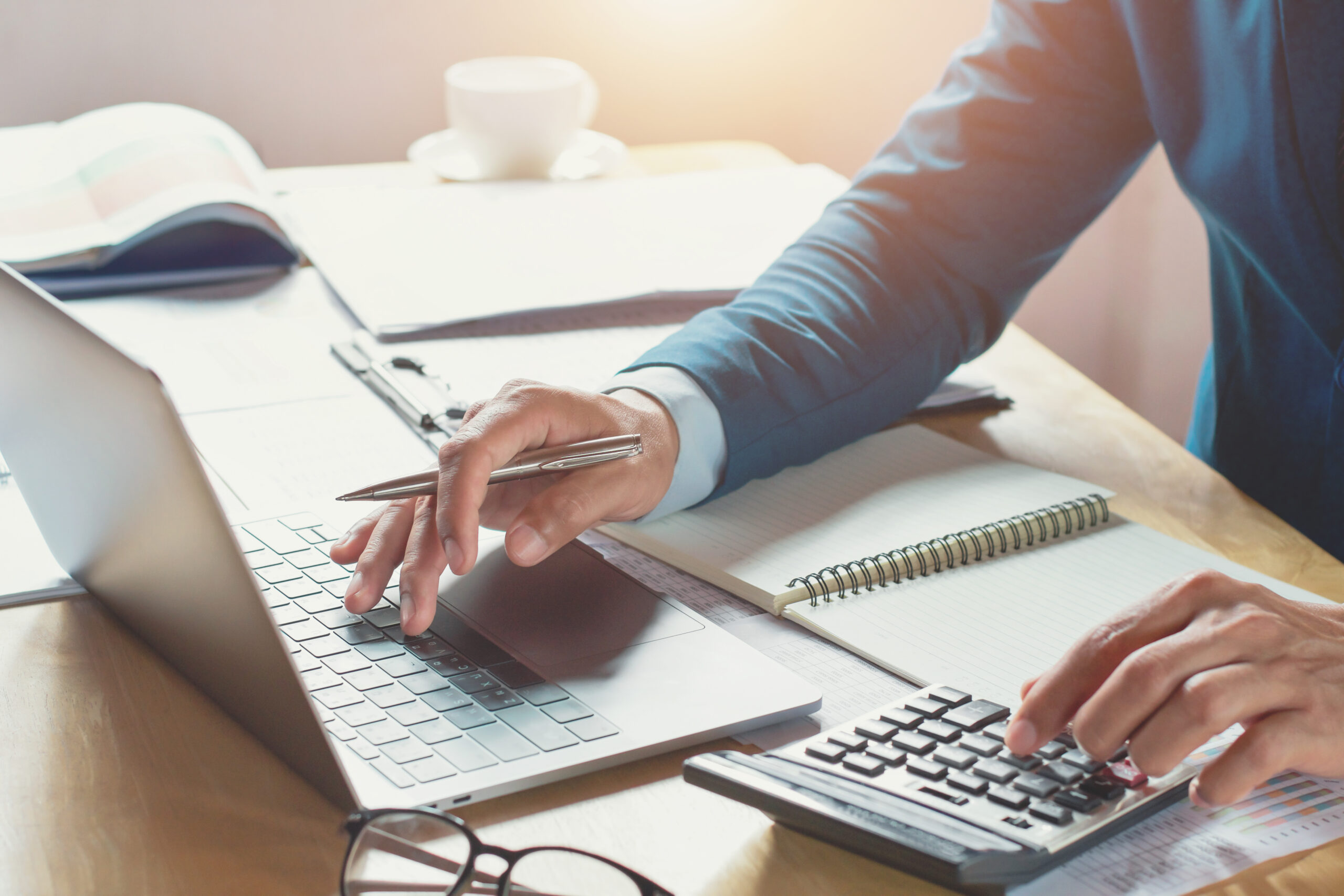 man-working-calculator-laptop-computer-finance-pen-documents