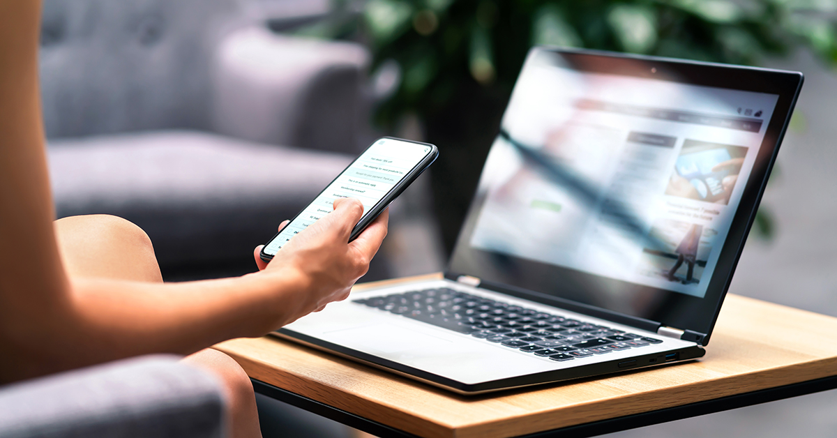 Woman researching Anti-SLAPP statutes on her phone and laptop at home